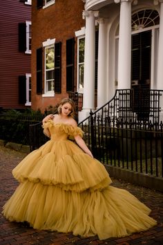 This yellow dream of a dress is such a statement piece with its tiered tulle skirt and off the shoulder, ruffled design. The color works well for all seasons and the full, voluminous skirt is simply a showstopper. This dress is extremely full, heavy and best suited to wear for a photoshoot where walking will be minimal or not required at all. Women's size 6 with a flexible (corset) back. Across the chest: 14.5 inches (corset back) Across the waist: 13 inches (corset back) Shoulder to hem: 56 inches in front, train in back Images: Taken at Camp Couture Salem Yellow Wedding Gown With Ruffles, Yellow Tulle Dress With Ruffles, Yellow Ruffled Tulle Dress, Gold Tulle Dress With Ruffles, Camp Couture, Outstanding Dresses, Rent Costumes, Tiered Tulle Skirt, Voluminous Skirt