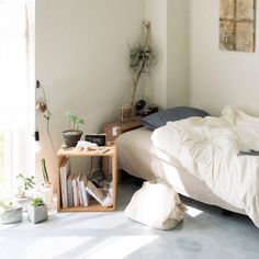 a bed sitting in a bedroom next to a wooden table with books on top of it