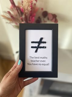 a person holding up a framed cross with the words, the best maths teacher ever you have no equal