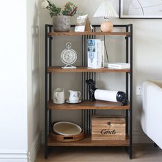 a book shelf with various items on it in a living room next to a couch