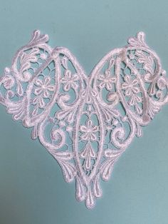 an intricately designed piece of white lace on a blue background with the word love written across it