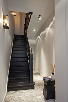 a staircase leading up to the second floor in a house with white walls and black railings