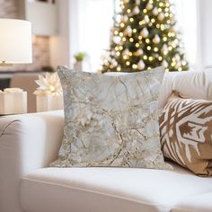 a living room with a white couch and christmas tree in the backgroung