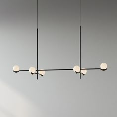 three lights are hanging from the ceiling in a room with gray walls and flooring