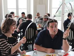 two people sitting at a table with food in front of them and hoop around their necks