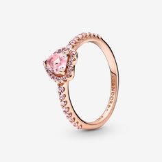 Add a sophisticated touch to your look with the Sparkling Elevated Heart Ring. The ring draws inspiration from the classic Pandora Timeless collection. Hand-finished in 14k rose gold unique metal blend, this piece features a pink heart-shaped central, elevated stone. Clear cubic zirconia create the halo and decorate half of the ring band, with the Pandora logo inside the shank. Stack this ring with hand-finished styles in sterling silver for a statement mixed metal look. Pandora Sparkling Elevat Elevated Heart Ring, Jewelry Chain Types, Pandora Rings Heart, Pink Heart Rings, Jewelry Making Rings, Charms Pandora, Pandora Rings, Fashion Ring, Pink Ring