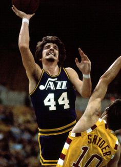 two basketball players jump for the ball during a game