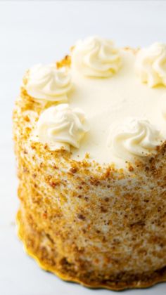 a cake with white frosting sitting on top of a table