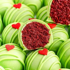 green macaroons with red heart decorations on them