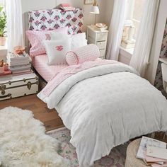 a bed with pink and white comforters in a bedroom