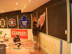 a man is painting the wall with hockey stickers