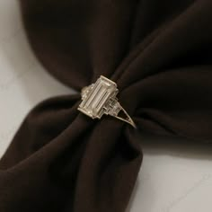 a diamond ring sitting on top of a brown cloth