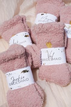 four bridesmaid slippers are laying on a bed