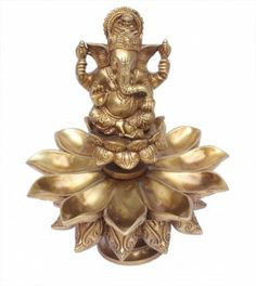 an elephant statue sitting on top of a gold leaf shaped object in the shape of a lotus