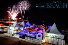 fireworks are lit up in the sky above tents