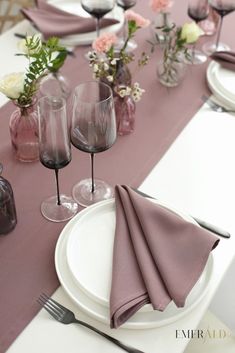 the table is set with wine glasses and napkins