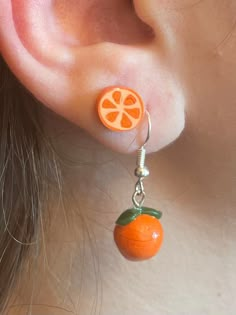 an orange slice is attached to a pair of earrings