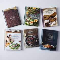 six cookbooks are laid out on a white surface