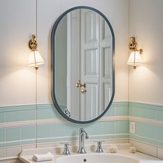 a bathroom sink with a mirror above it and two lights on the wall next to it