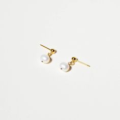 Elevate your everyday look with these stunning Pearl Drop Studs. These tiny dangle earrings feature fresh water pearls, perfect for both dressing up or keeping it casual. Enjoy subtle sophistication all day long with this timeless and minimalistic pair. 5-6 mm off-round fresh water pearls. Wire wrapped and hung from a stud for a petite dangle style. Select from 14k gold fill or sterling silver. These feel weightless in your ear. Each pair of earrings come with a matching set of fine metal and si Classic Everyday Pearl Drop Earrings, Minimalist Pearl Earrings For Pierced Ears, Minimalist Pearl Drop Earrings, Minimalist Pearl White Pearl Chain Earrings, Minimalist Round Pearl Earrings, Dainty Everyday Pearl Earrings, Classic Pearl Earrings With Pearl Chain For Everyday, Minimalist Pearl Earrings With Charm, Minimalist Pearl Earrings For Everyday