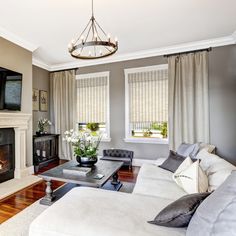 a living room filled with furniture and a flat screen tv mounted on the wall next to a fire place