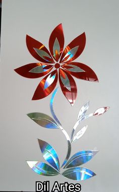 a red and silver metal flower hanging from the ceiling