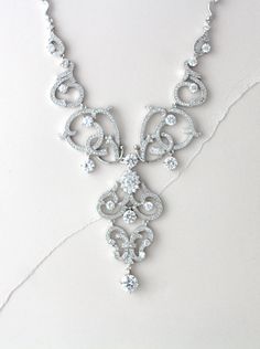 In silver rhodium plating this crystal bridal necklace is truly beautiful ! Scrolls upon scrolls of Swarovski Pure Brilliance cubic zirconia encrusted elegance. At the center of the necklace is a beautiful oval cz stone surrounded by small cz stones. This necklace is perfect for any special occasion gown. Necklace measures 18 inches and comes with 2 inch extension chain. LISTING IS FOR NECKLACE ONLY MATCHING PIECES: https://www.etsy.com/listing/252455207/crystal-bridal-earrings-chandelier https: Silver Crystal Necklace With Intricate Design, Exquisite Cubic Zirconia Wedding Necklaces, Exquisite Silver Bridal Necklace With Elegant Design, Exquisite Cubic Zirconia Wedding Necklace, Silver Bridal Necklace With Elegant Cubic Zirconia Design, Silver Bridal Necklace With Cubic Zirconia, Silver Necklace With Intricate Crystal Design, Silver Bridal Necklace With Intricate Crystal Design, Dazzling Crystal Bridal Necklace With Intricate Design