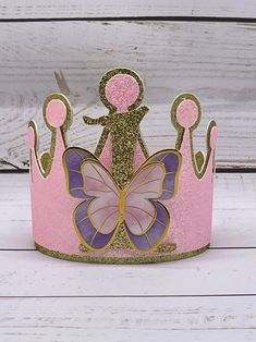 + gold + pink sparkle tiara adorned with a sparkle gold 1 + pastel purple + pink butterflies   packaged inside a coordinating gift box Whimsical Gold Crown For Party, Pink Pinched Crown For Party, Whimsical Tall Crown As Gift, Pink Princess Crown For Party, Princess Crown Party Supplies For Birthday, Whimsical Pink Crown For Birthday, Gold Birthday Crown With Tall Shape, Gold Tall Crown For Birthday, Whimsical Pink Birthday Party Supplies