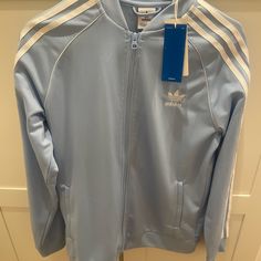 Baby Blue Adidas Track Jacket Size Xl, New With Tags, Never Worn Blue Track Jacket For Spring Streetwear, Blue Spring Sports Outerwear, Adidas Long Sleeve Track Jacket For Spring, Adidas Long Sleeve Spring Track Jacket, Blue Track Jacket For Sports In Spring, Blue Track Jacket For Spring Sports, Spring Blue Track Jacket For Sports, Casual Adidas Outerwear, Blue Sporty Outerwear With Ribbed Cuffs