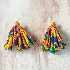 Beneath beads of natural cat's eye frills of cotton fabric printed with colorful African motifs dangle. Ghanaian artisan Lydia Mawuenya Amedzrator creates these earrings which swing from brass hooks. These earrings are named Ohemaa which means queen in the Akan language. Beautiful Jewelry Fabric, African Earrings Handmade Inspire Uplift ⭐, Cute Earrings Fabric, African Earrings Handmade Afrikrea.com, African Knotted Leather Earrings, Affordable Handmade Festival Earrings, Cheap Handmade Earrings For Festivals, Cheap Handmade Festival Earrings, African Jewelry Earrings Simple