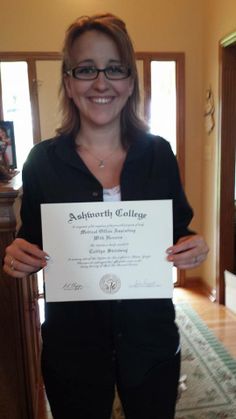 a woman holding up a certificate in her hands