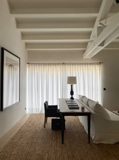 a living room filled with furniture and a large window covered in white draping