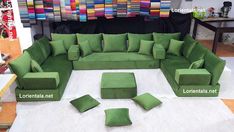 a large green couch sitting on top of a white rug