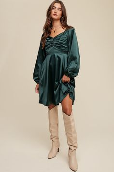 -Color: Deep Green -Cinched long sleeve satin dress -Sweetheart neckline with elastic -Stretched -Long puff sleeves with elastic cuffs -Smocking on back -A-line skirt -Hidden side seam pockets -Finished with clean hem -Lined -Imported -Content: 95% Polyester 5% Spandex -Model is 5' 7" 31-24-35 and wearing a size Small Fall Satin Mini Dress Knee-length, Satin Dress With Gathered Balloon Sleeves, Long Sleeve Dress With Gathered Neckline For Party, Long Sleeve Fitted Ruched Satin Dress, Long Sleeve Party Dress With Gathered Neckline, Elegant Dress With Smocked Back And Bishop Sleeves, Evening Dress With Gathered Neckline And Long Sleeves, Long Sleeve Dress With Smocked Back For Evening, Long Sleeve Dresses With Smocked Back For Date Night