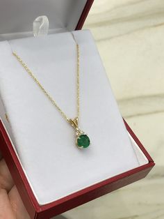 Featured here is a stunning, round natural emerald & diamond necklace in fine 14K yellow gold. Displayed is a medium-green emerald with very good transparency, accented by a simple four-prong mount allowing for the emerald to be shown in full view. The earth mined green emerald has a desirable rich green color with excellent qualities. Three diamond accents are placed on top of the emerald! This pendant is ideal for everyday use and is the perfect accessory to any outfit. This pendant comes Gold Diamond-cut Emerald Necklace, Classic Emerald Necklace With Diamond Accents, Classic Round Emerald Necklace With Diamond Accents, Round Emerald Necklace With Diamond Cut, Round Diamond Cut Emerald Necklace, Green Round Diamond Cut Necklace, Classic Green Diamond Pendant Necklace, Gold Emerald Pendant Necklace With Prong Setting, Classic Gold Emerald Necklace