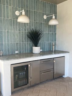 a kitchen counter with two lights and a potted plant