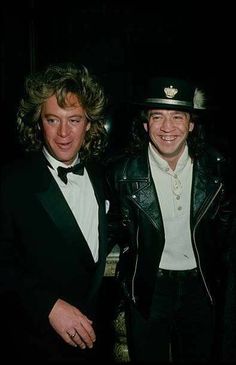 two men in tuxedos pose for the camera