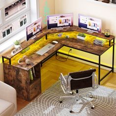 a computer desk with three monitors on it and a chair in front of the desk