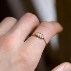 a woman's hand with a diamond ring on top of her finger, showing the band