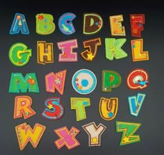 the letters and numbers are made out of colored felt on a blackboard with scissors