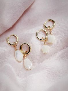 The Lei Hoops reflect Hawaii's natural abundance and beauty. These small gold mother of pearl and gold huggie hoop earrings feature darling carved seashell flower charms reminiscent of Hawai'i's flower leis. These pretty gold hoops are perfect solo or teamed with our some huggie hoops.Handmade on Maui, Hawaii. ✦ Choose from two flower styles: Tulip or Pikake ✦✦ DETAILS ✦✧ Name: Lei (LAEE) - garland.✧ 18kt Gold Vermeil.✧ 25mm & 29mm Drop Length✧ 12mm hoop outer diameter, 9mm inner diameter, & 2.5 Flower Charm Huggie Earrings As Gift, Gift Jewelry Flower Charm Huggie, Huggie Jewelry With Flower Charm For Gift, Huggie Jewelry With Flower Charm As Gift, Dainty White Dangle Huggie Earrings, Dainty White Huggie Dangle Earrings, Dainty White Jewelry With Dangling Charms, Dainty White 14k Gold Filled Huggie Earrings, Delicate Pearl Charm Huggie Jewelry