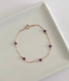 This dainty amethyst bracelet is handmade with genuine amethyst, and 14k gold filled and sterling silver metals. - Each bead measures 3mm. - Waterproof - Will not tarnish - Size up and wear as an anklet All of our jewelry is handmade with love in Nova Scotia, Canada. METALS Our jewelry is made using 925 sterling silver or 14k gold filled metals. Gold filled metals are made with a thick layer of gold to a brass core. Is is of higher quality than plated jewelry, and is a great alternative to pure Dainty Amethyst Jewelry With Adjustable Chain, Elegant Purple Birthstone Beaded Bracelets, Purple Amethyst Bracelets As Gift, Purple Amethyst Bracelet For Gift, Purple Amethyst Birthstone Bracelet, Dainty Amethyst Bracelet Jewelry, Dainty Gold Amethyst Bracelets, Elegant Purple Chain Bracelet As Gift, Everyday Purple Amethyst Bracelet