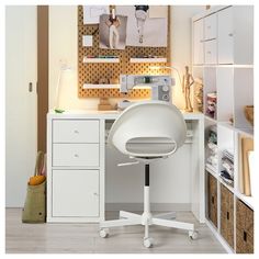 a white chair sitting in front of a desk with a sewing machine on top of it