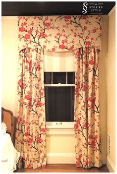 the window is decorated with red flowers and black trim on it's valance