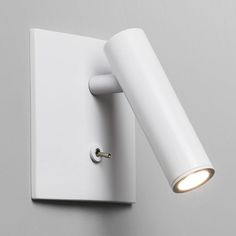 a white wall light mounted on the side of a gray wall