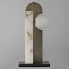 a marble and wood lamp on a wooden base with a white ball in the center