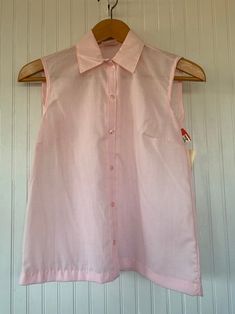 "NEW with original tags From the early 80s! Vintage Pastel Baby Pink Sleeveless Top with button down closure. Size S. Darts on chest. Authentic vintage deadstock from the early 80s, New With Tags! Brand - Land n' Sea Made in USA 65% Polyester 35% Cotton Machine Washable Condition - Original Deadstock from the 80s, New With Tags Vintage Size - 34 Fits Like - Small (see measurements) Measurements (Seam to seam, lying flat) - Bust* - 34\" Waist* - 38\" Length - 23\" *Measurements doubled for bust a Cotton Button-up Vest Top, Summer Cotton Vest With Snap Buttons, Sleeveless Cotton Shirt For Daywear, Sleeveless Shirt For Spring Daywear, Sleeveless Spring Daywear Shirt, Sleeveless Spring Tops With Snap Buttons, Sleeveless Tops With Snap Buttons For Spring, Retro Cotton Vest With Buttons, Classic Summer Tank Top With Buttons