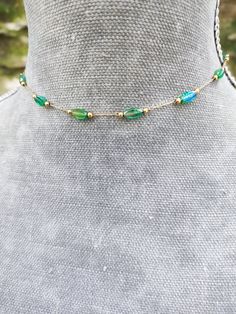 Super dainty emerald green crystal beaded choker made from gold plated stainless steel and beautiful little long green crystals. PLEASE read my shop announcement before placing an order so you know what to expect right now. Plus, when ordering from outside Europe, don't forget to provide a phone number for the courier to ensure the fastest and smoothest delivery Stainless steel chain and findings, won't rust or anything  Fastens with a solid lobster clasp, and has an extension chain.   Choker is Gold Emerald Bead Necklaces, Gold Emerald Round Bead Necklaces, Wire Wrapped Choker Jewelry, Green Delicate Chain Jewelry For May Birthstone, Dainty Green Jewelry With Delicate Chain, Green Choker Necklace With Adjustable Chain, Gold Beaded Necklaces For May Birthstone, Bohemian Style Gold Emerald Necklace With Round Beads, Bohemian Gold Emerald Necklace With Round Beads