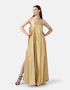 Chic, comfortable and edgy, this gold strapless pleated maxi dress offers a highly flexible fit with an adjustable button closure at back. Dress comes in ankle length or floor length, refer to size guide for dress length. High rise pleating, gold button details, and a stylistic belt tie at the bust add flare to the designs minimalist charm. The medium weight fabric, cruelty free vegan leather, has a loosely structured drape for a relaxed and remarkably comfortable fit. You'll be kept warm in coo Strapless Pleated Maxi Dress For Gala, Gala Maxi Dress With Folds, Summer Gala Strapless Pleated Dress, Summer Gala Pleated Strapless Dress, Pleated Strapless Dress For Summer Gala, Gold Strapless Dress For Gala, Strapless Pleated Maxi Evening Dress, Gold Sleeveless Maxi Dress For Gala, Gold Strapless Dress For Evening