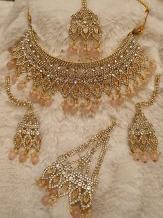 a gold necklace and earrings on a white fur